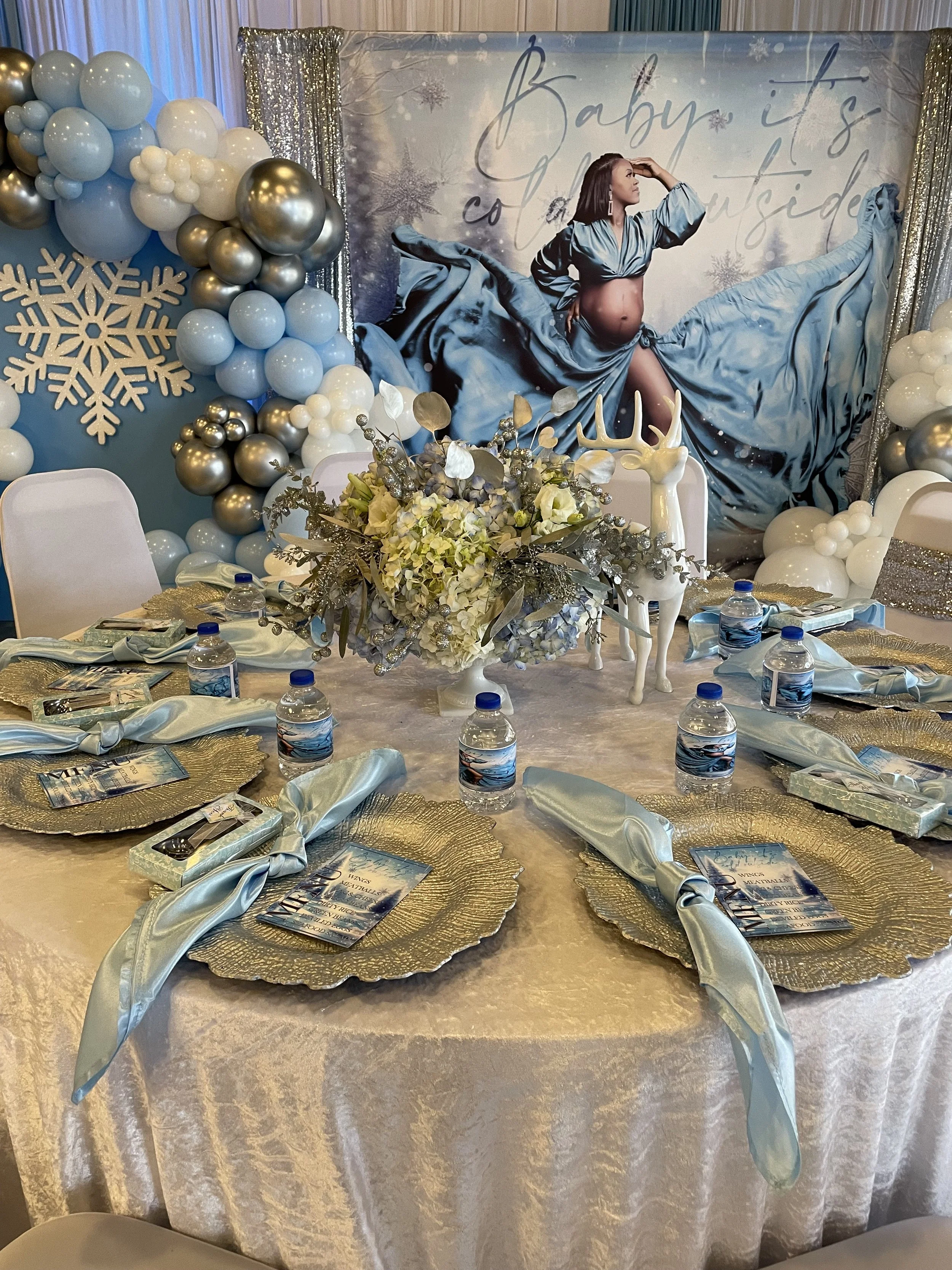 Blue baby shower backdrop with a balloon garland and snowflake details by Sharp Designs