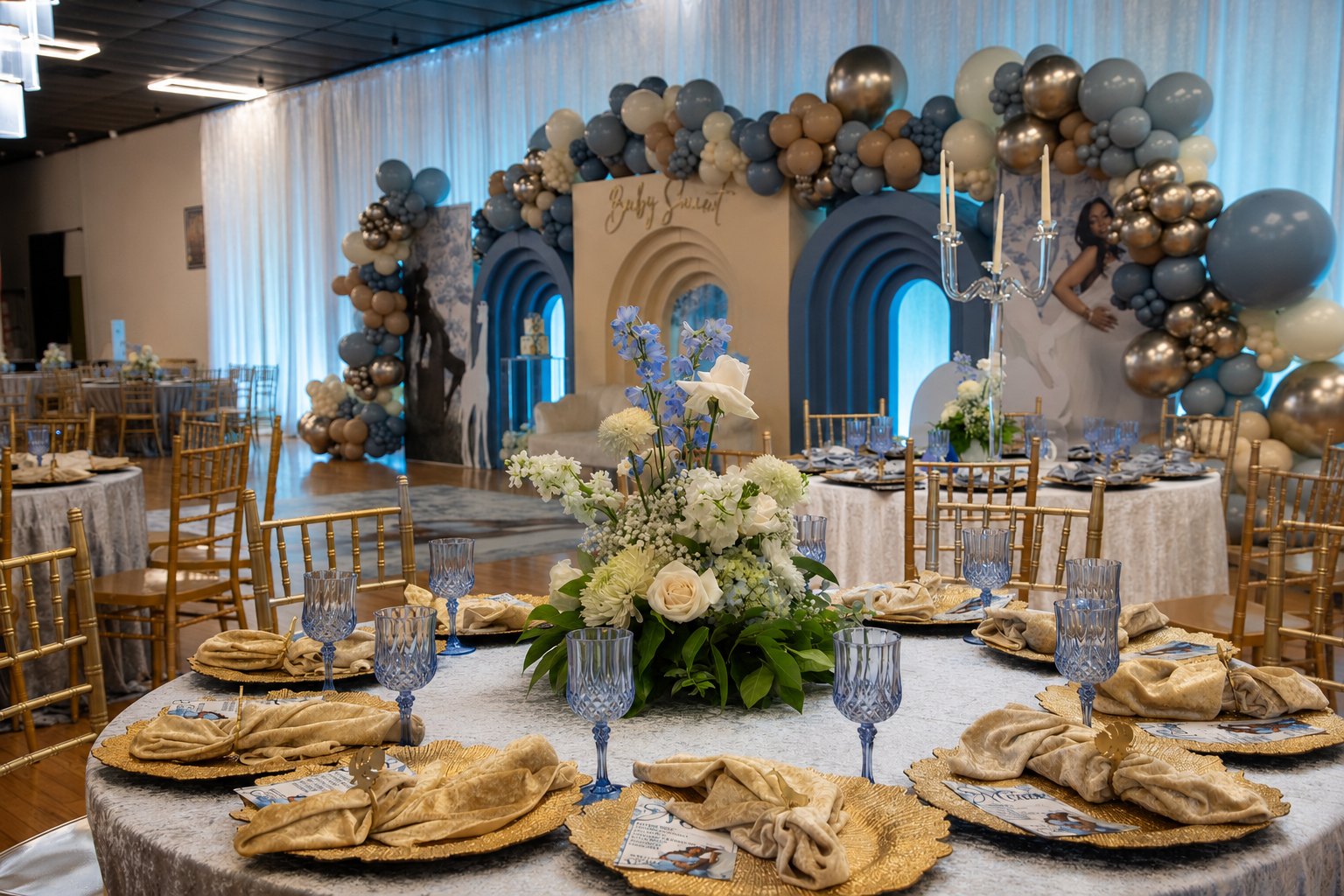 Ballroom event styled by Sharp Designs Events and Rentals with arched backdrops, a balloon garland, gold chiavari chairs and centerpieces at a Jacksonville venue